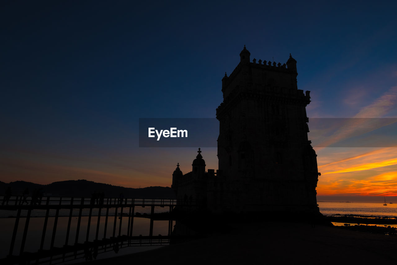 Belem tower silhouette over burning sunset in lisbon portugal 