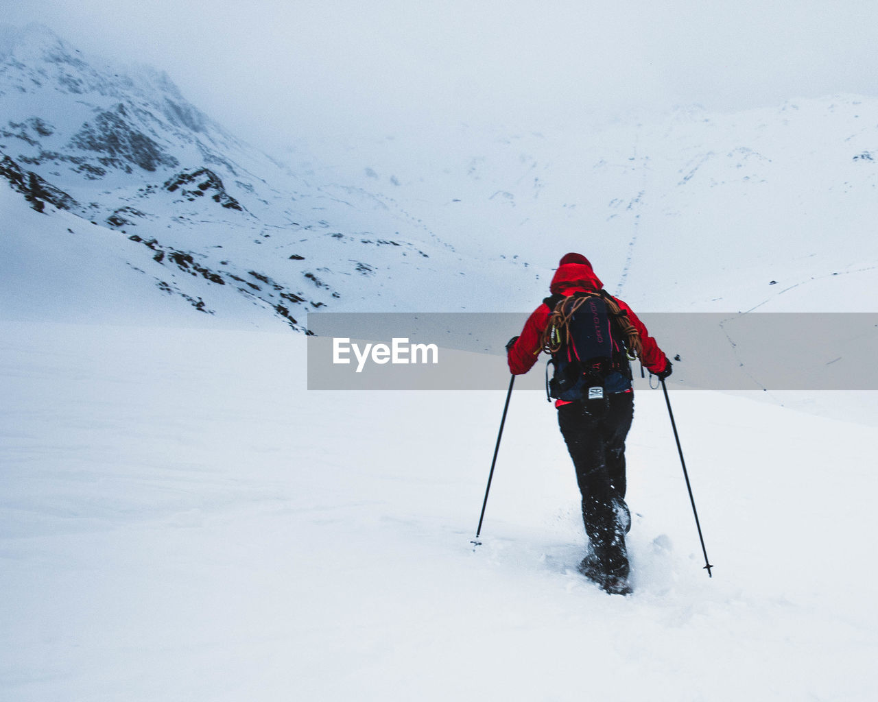 Rear view of person skiing on snowcapped mountain