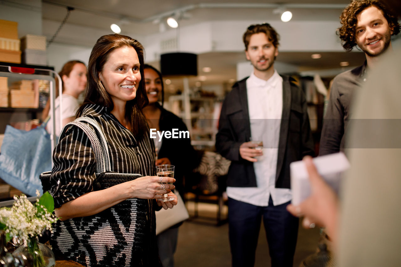 Saleswoman talking to customers while showing perfume at store