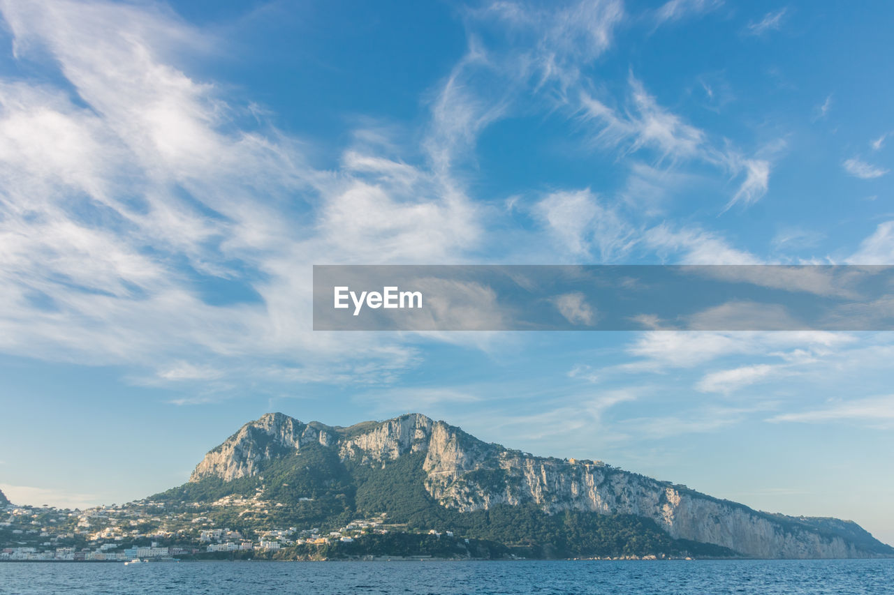 Scenic view of sea and mountains against sky