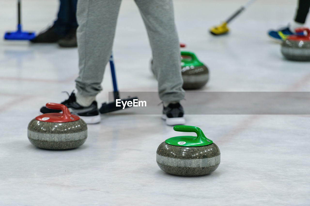 Low section of man playing curling on ice rink