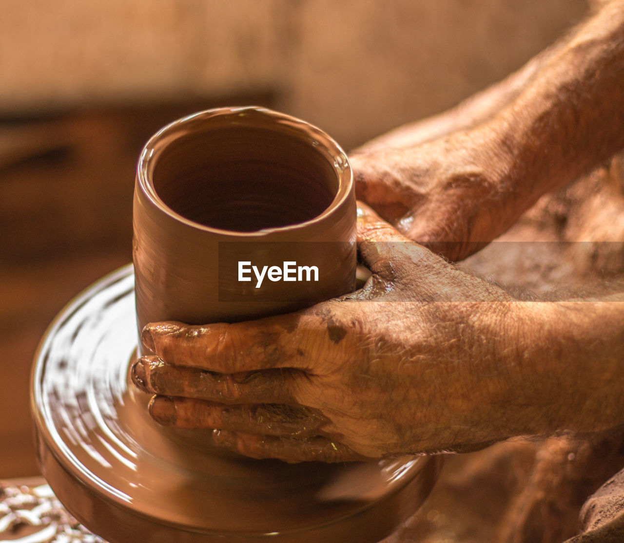 CLOSE-UP OF HAND HOLDING COFFEE CUP