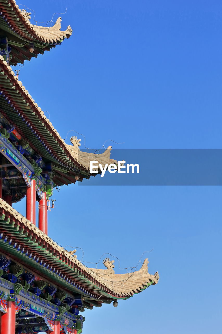 LOW ANGLE VIEW OF TRADITIONAL BUILDING AGAINST BLUE SKY