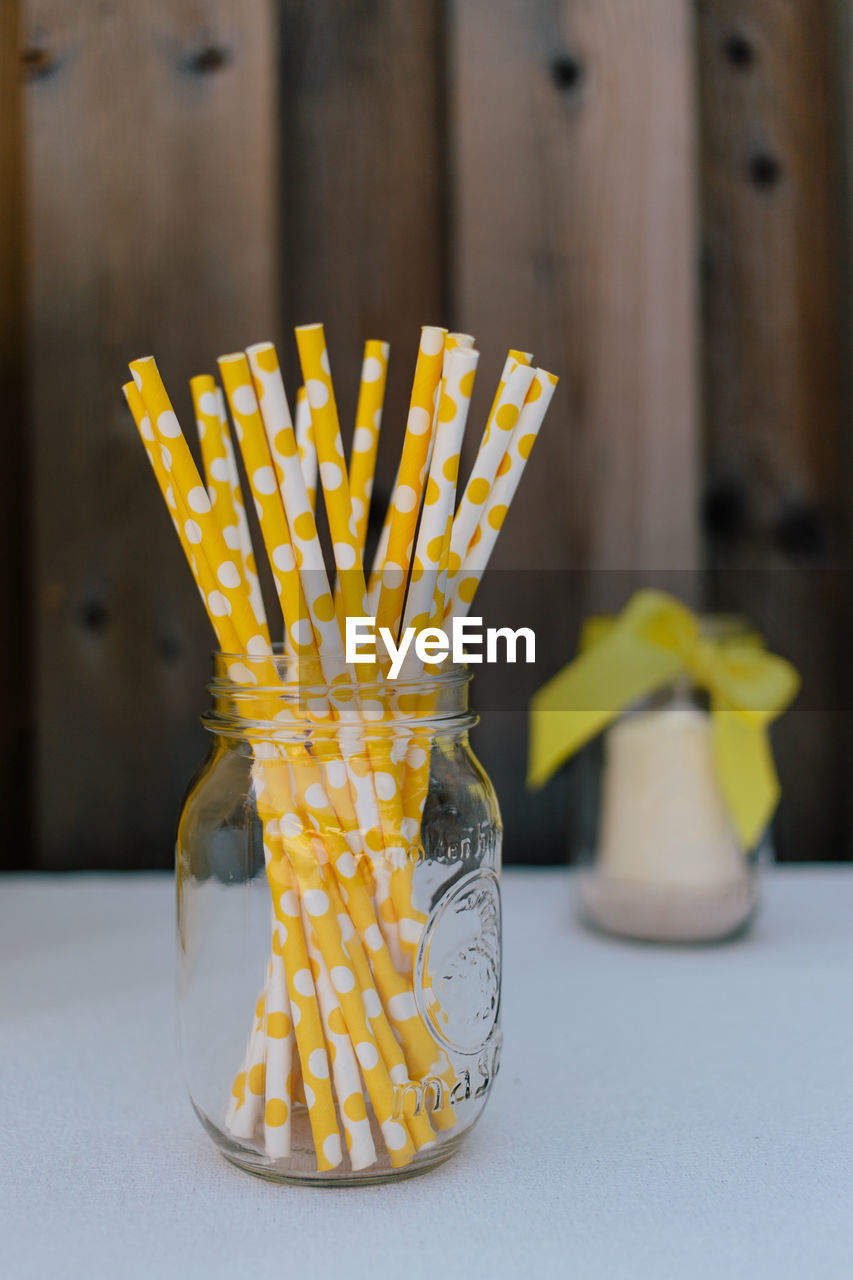 Close-up of straws in glass jar on table