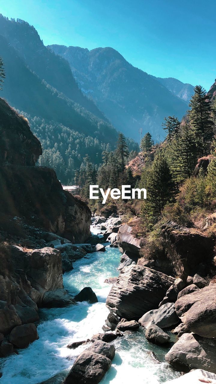 Scenic view of river amidst mountains against sky