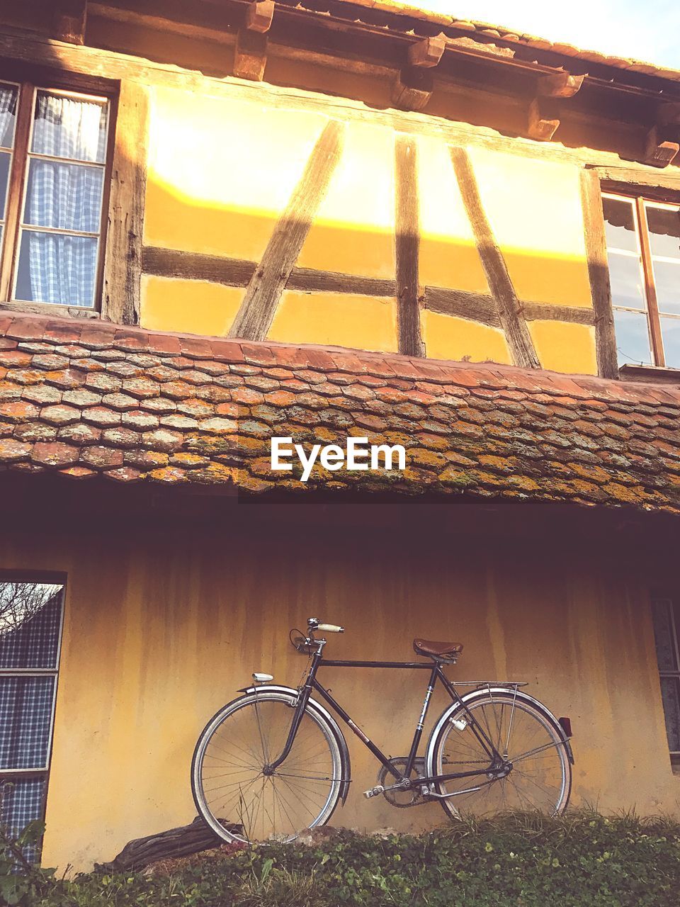 BICYCLE PARKED AGAINST WINDOW