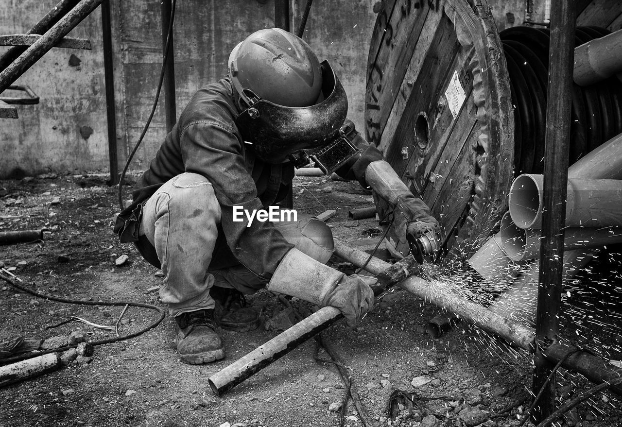 Manual worker welding metal at workshop