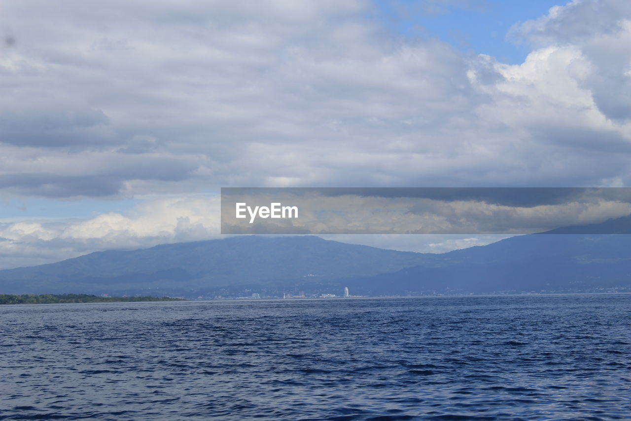 SCENIC VIEW OF SEA BY MOUNTAIN AGAINST SKY