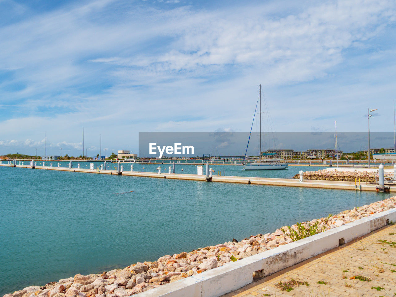 water, sky, sea, transportation, coast, shore, architecture, nature, cloud, dock, nautical vessel, vacation, beach, marina, land, bay, travel, built structure, harbor, sailboat, travel destinations, pier, ocean, day, mode of transportation, no people, city, walkway, blue, scenics - nature, horizon, outdoors, beauty in nature, body of water, tourism, holiday, tranquility, trip, vehicle, sunlight, building exterior, ship, environment, coastline, tranquil scene, landscape, bridge, sailing ship, idyllic