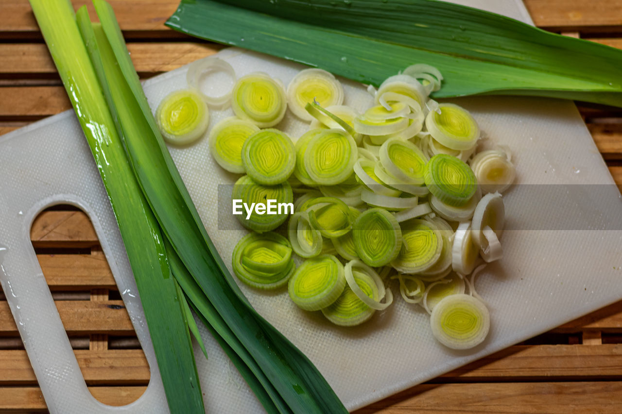 food, food and drink, freshness, healthy eating, wellbeing, vegetable, produce, plant, wood, dish, cutting board, leek, indoors, high angle view, green, still life, no people, kitchen knife, table, fruit, slice, cuisine, ingredient, spice, raw food, domestic room