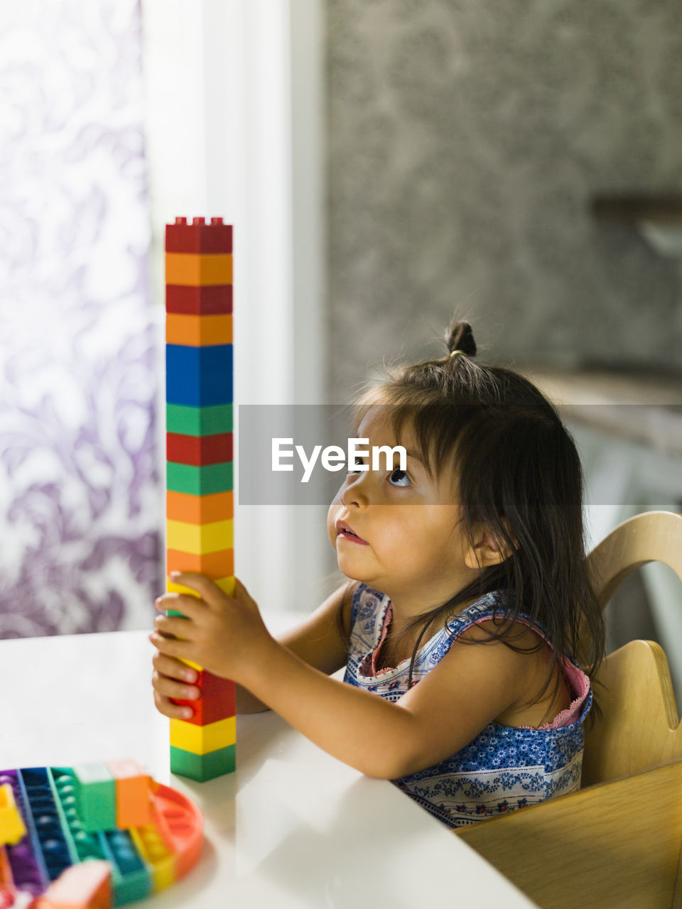 Girl stacking blocks at table