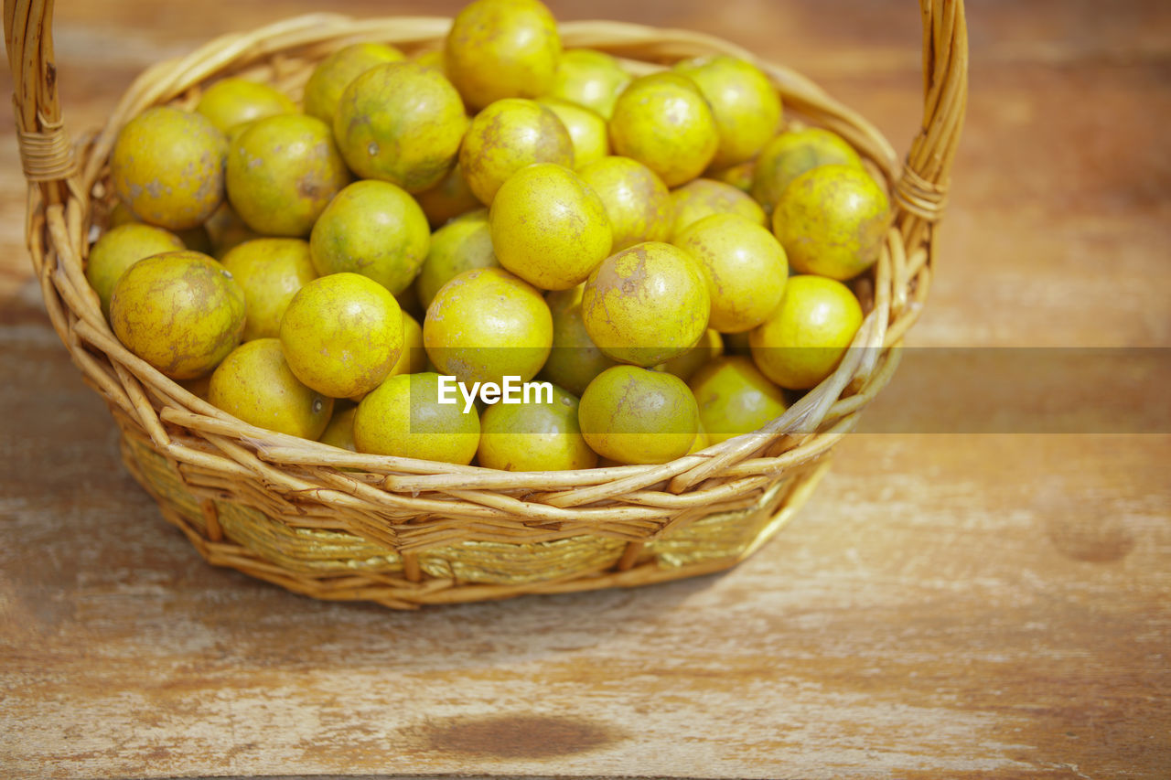 Fresh orange tangerine fruit in rattan wicker basket on wooden chair