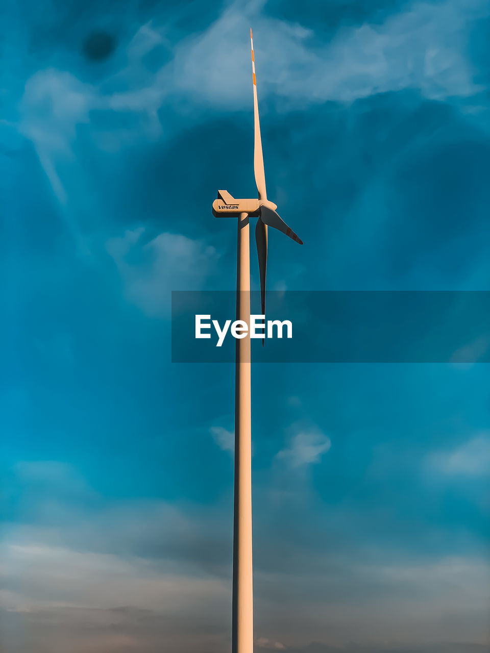 Low angle view of wind turbine against blue sky