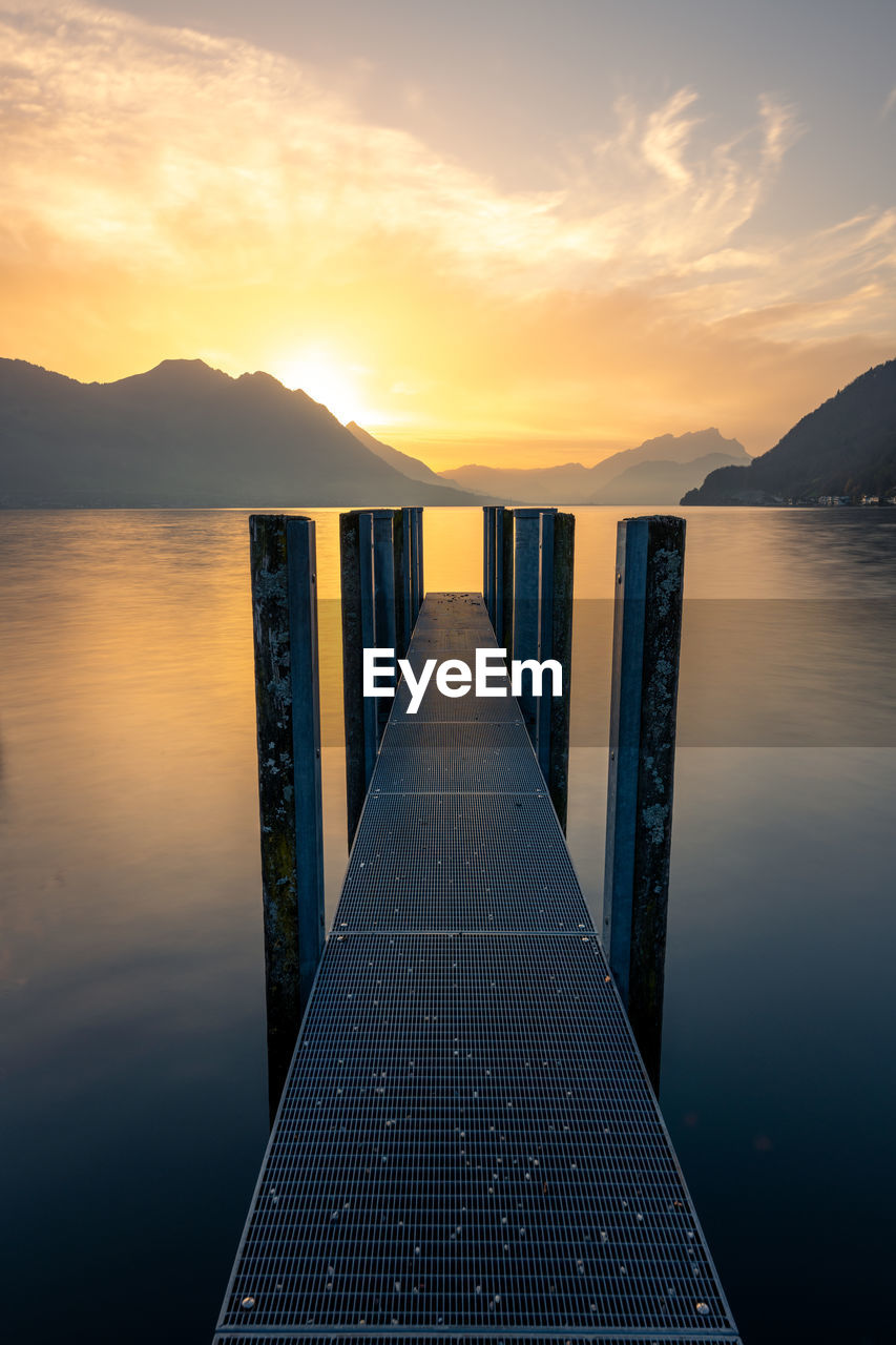 pier over sea against sky during sunset