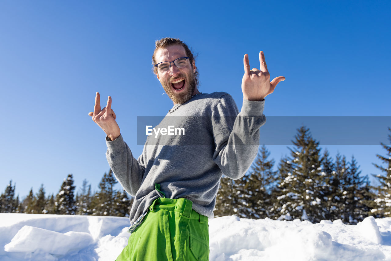 PORTRAIT OF SMILING MAN STANDING IN SNOW