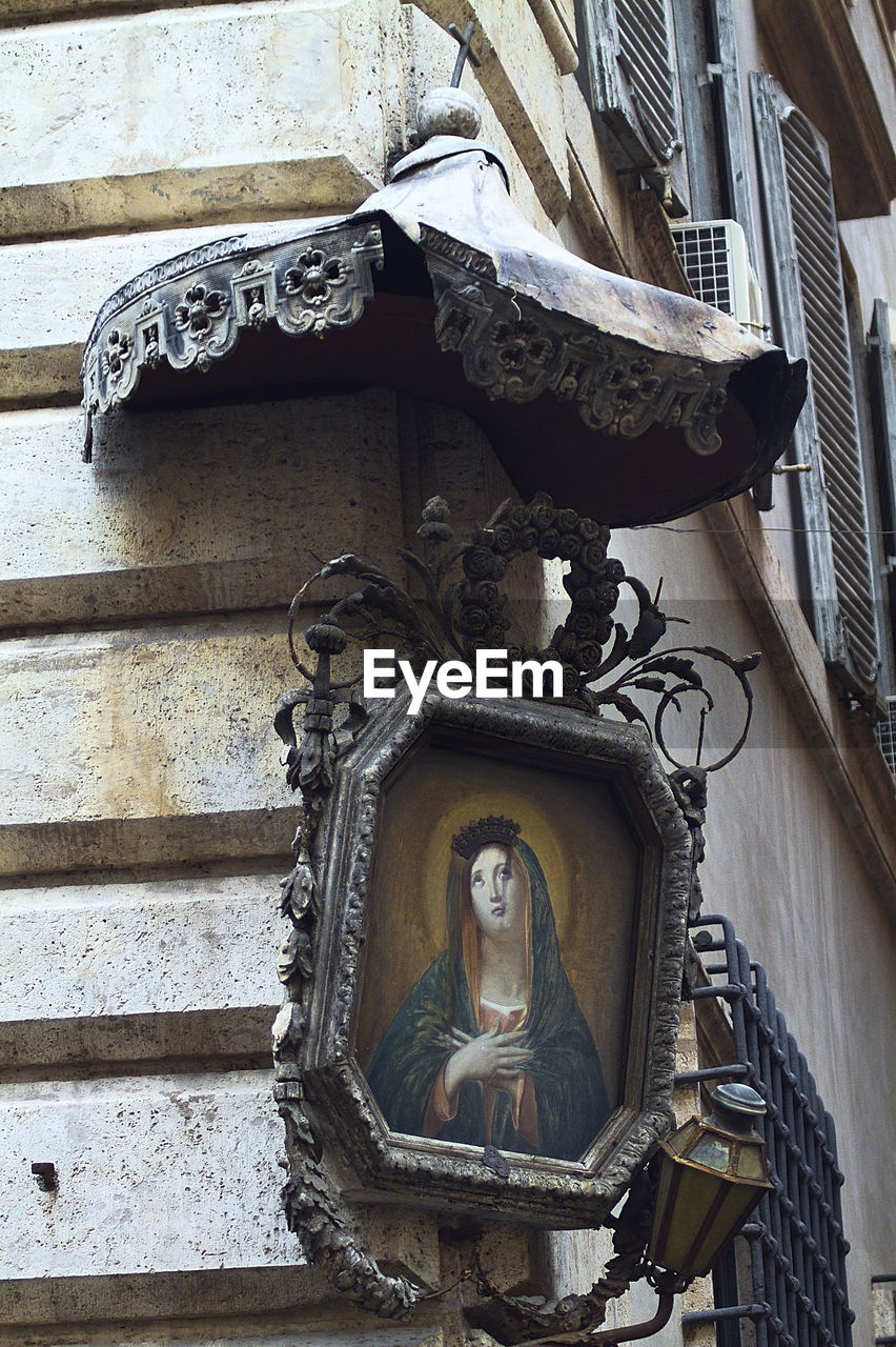 CLOSE-UP OF STATUE AGAINST BUILDING