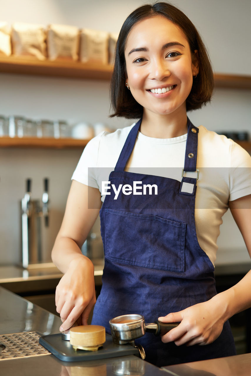 portrait of smiling young woman sitting at table