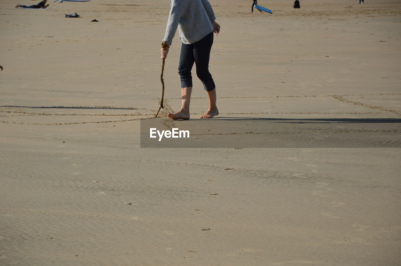 land, beach, sand, lifestyles, leisure activity, walking, nature, adult, men, holiday, day, water, vacation, trip, low section, sea, women, one person, human leg, motion, casual clothing, person, outdoors, rear view, sunlight, standing, travel, barefoot, clothing, sports, footprint