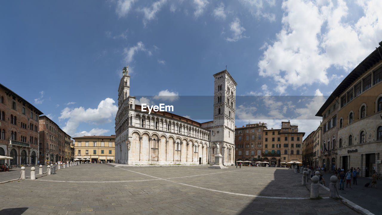 Lucca, Tuscany, Italy. August 2020. Amazing view of the Church of San Michele in Foro. Large format panoramic photo. Beautiful sunny day, people in the square. Ancient Archangel Michael Architectural Architecture Art Basilica Bell Tower Building Cathedral Catholic Catholicism Church City Cityscape Column Europe European  Exterior Façade Format Foro  Historic History Italian Italy Landmark Large Life Lifestyle Lucca Marble Medieval Michael Monument Old Panoramic People Photo Religion Romanesque