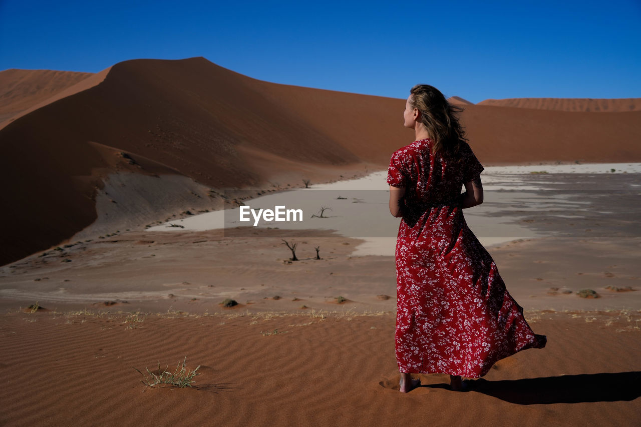 rear view of woman standing at desert