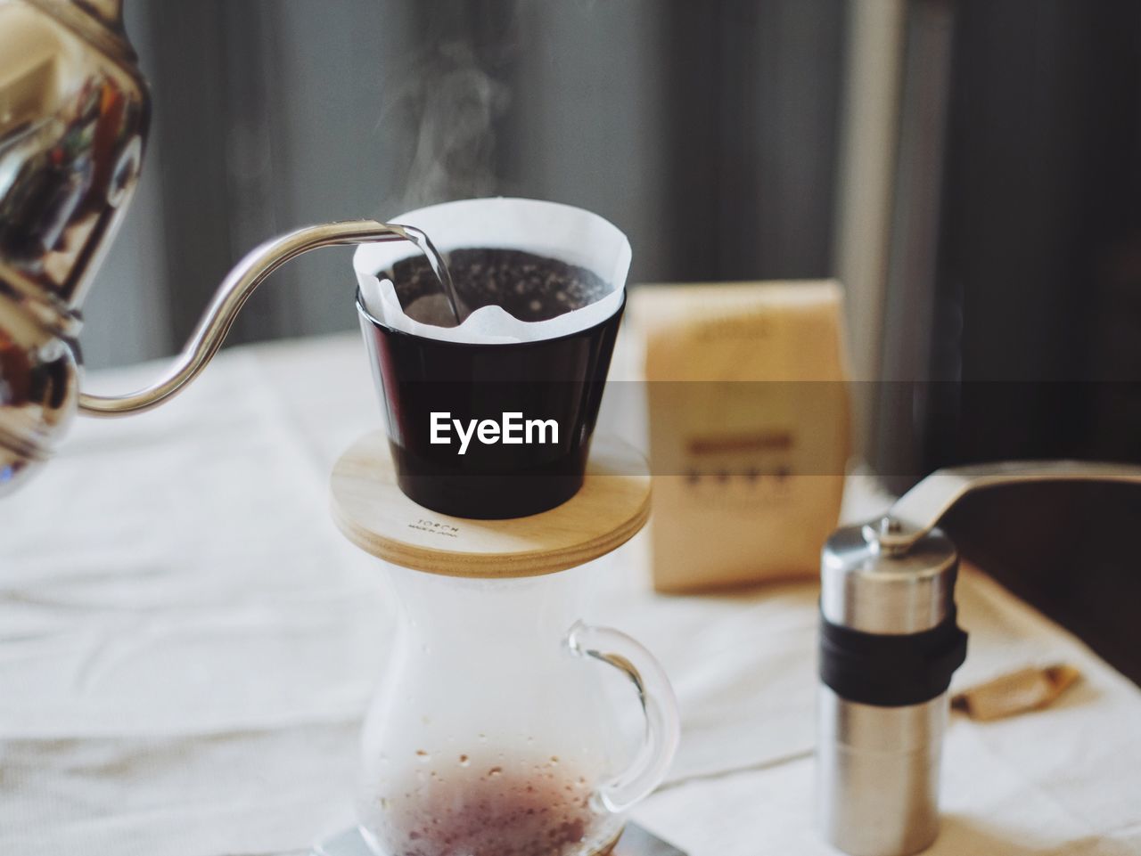 Hot water being poured in coffee filter on table