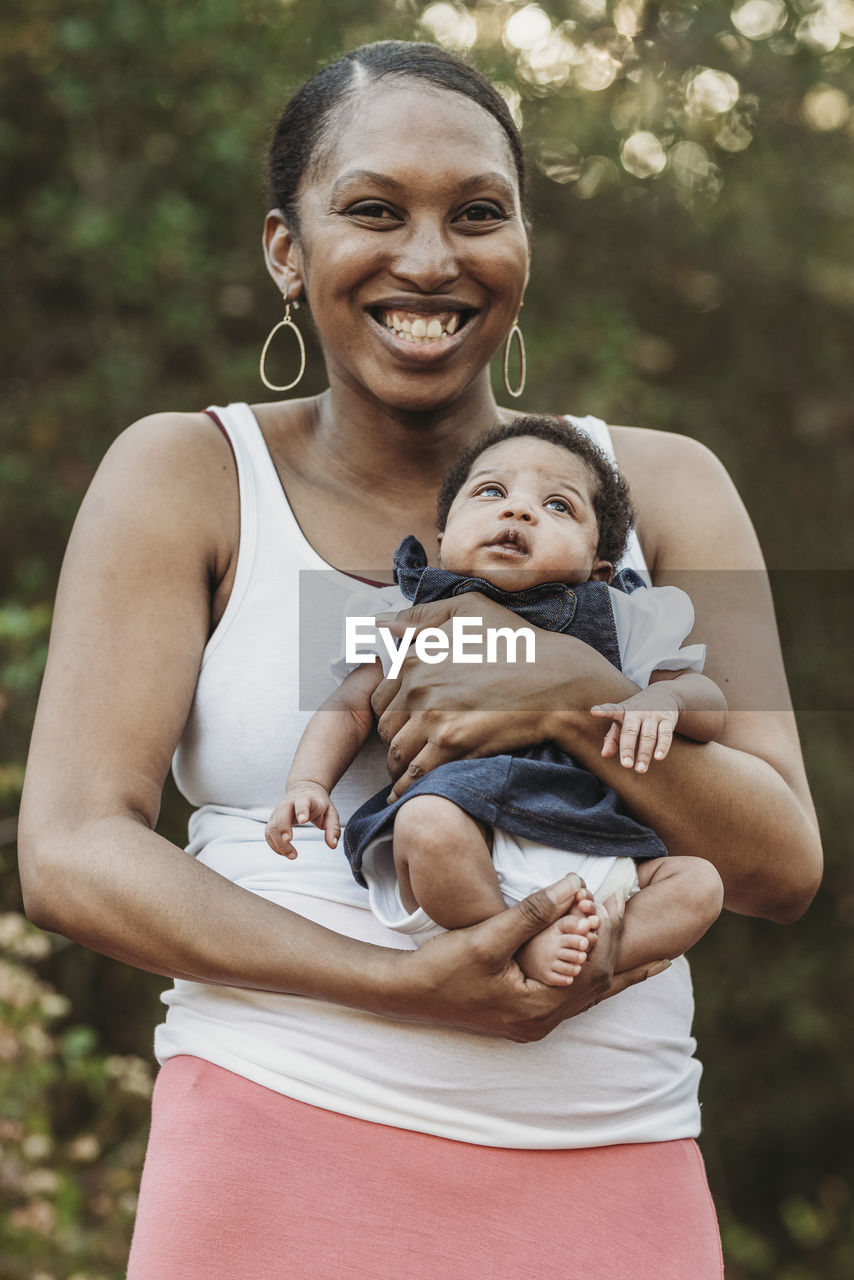 Close up portrait of young mother holding newborn age daughter