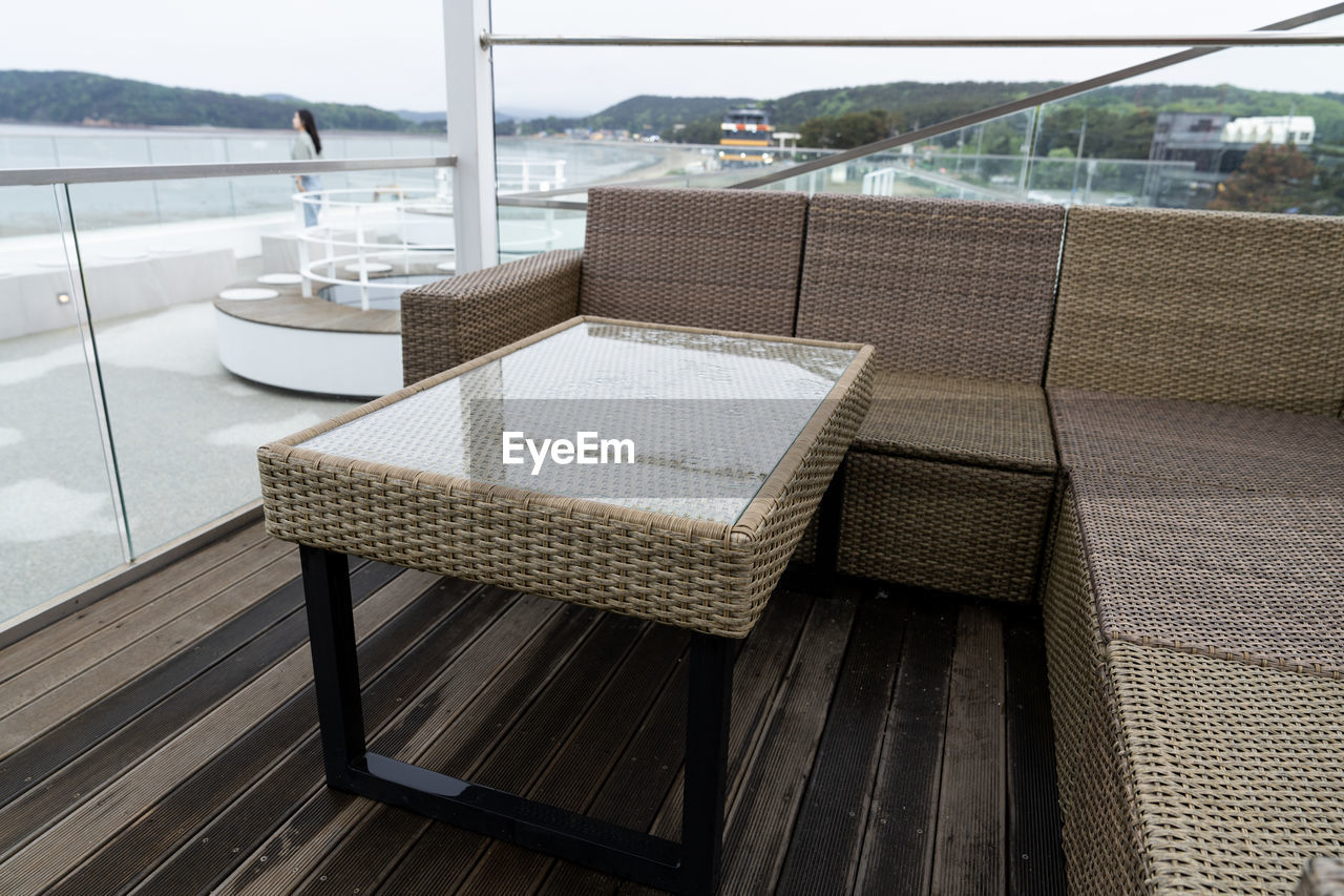water, sea, seat, chair, luxury, architecture, furniture, nature, wealth, no people, day, relaxation, deck, wood, built structure, table, outdoors, sky, building exterior, patio, tranquility, travel, land, travel destinations, beach, vacation, absence, outdoor structure, lifestyles, floor, trip, window, scenics - nature, studio couch, holiday, sofa, tranquil scene, comfortable