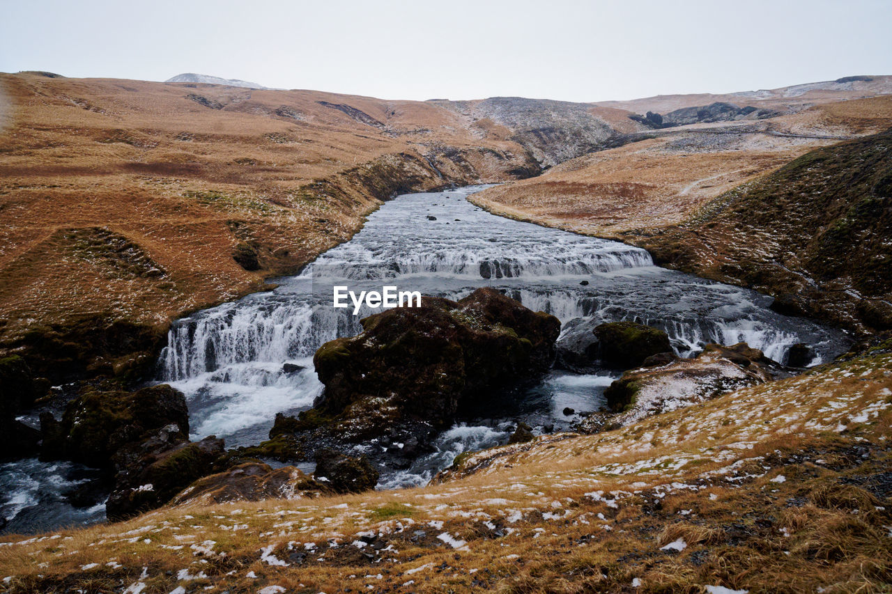 Scenic view of waterfall by rock formation