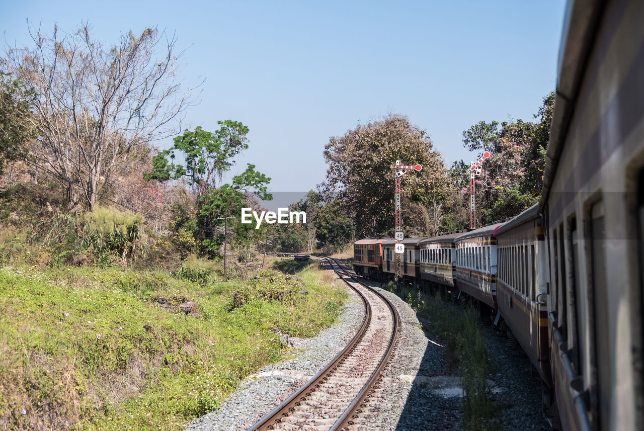 The diesel-electric locomotive of the express train is moving past the signal pole on the mountain.