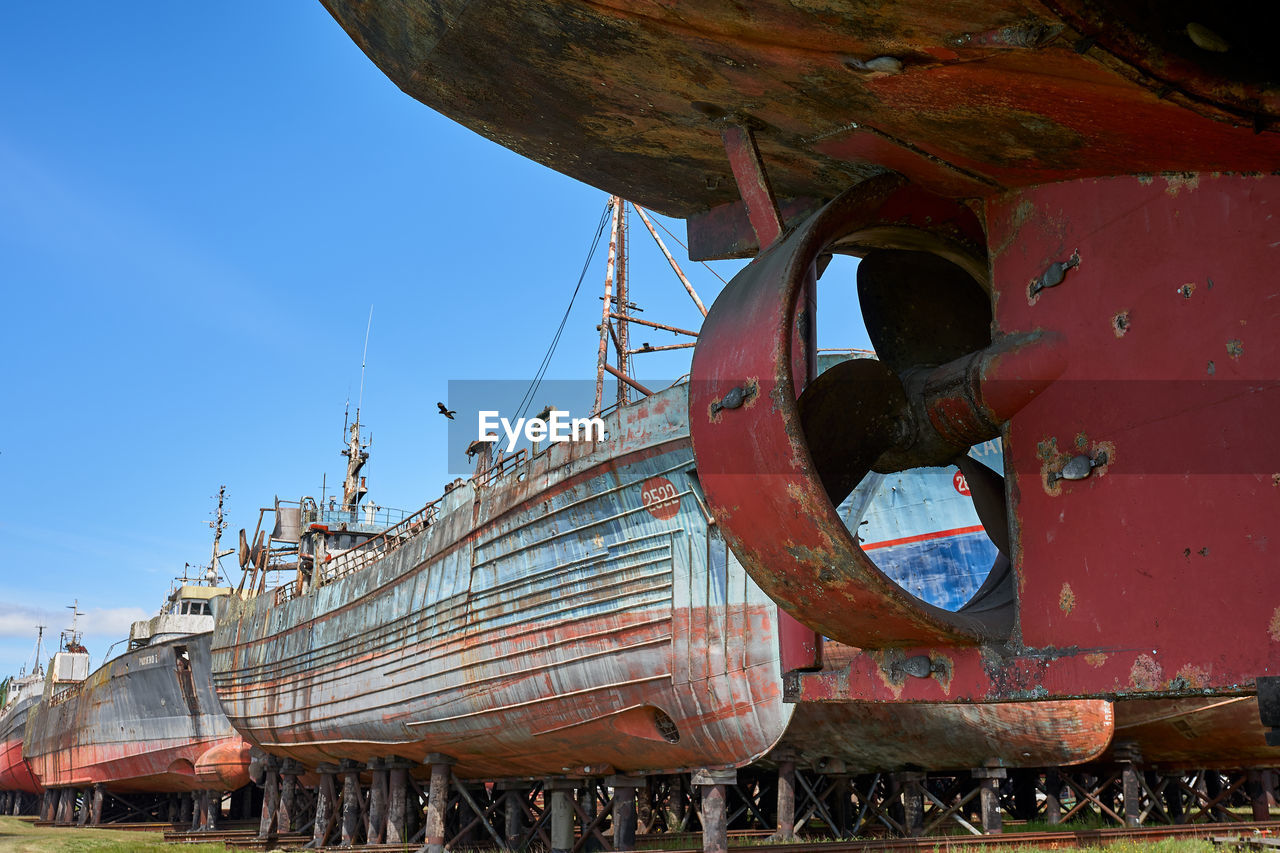 Abandoned ship moored in water against clear sky