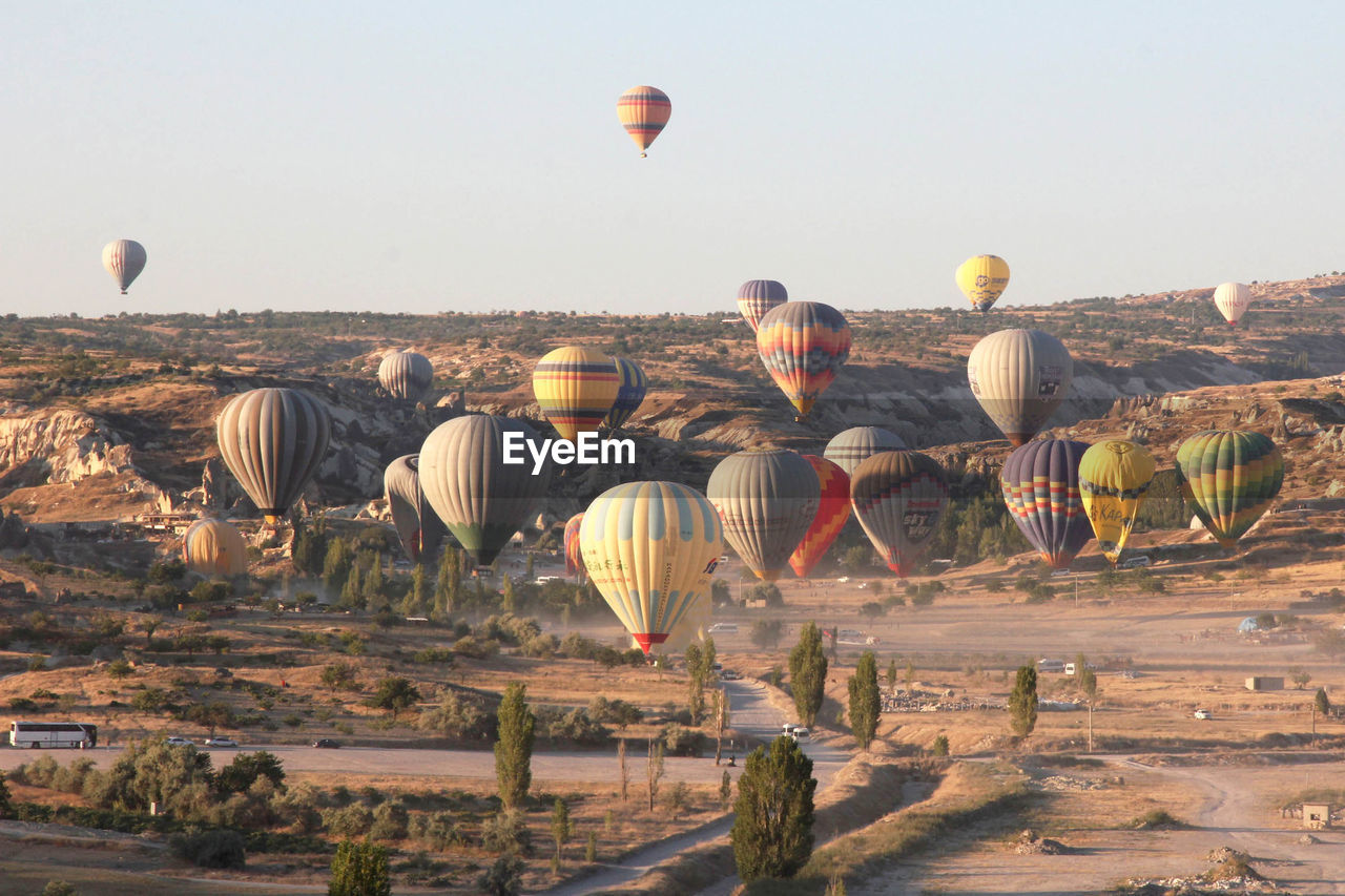 VIEW OF HOT AIR BALLOONS FLYING OVER LAND