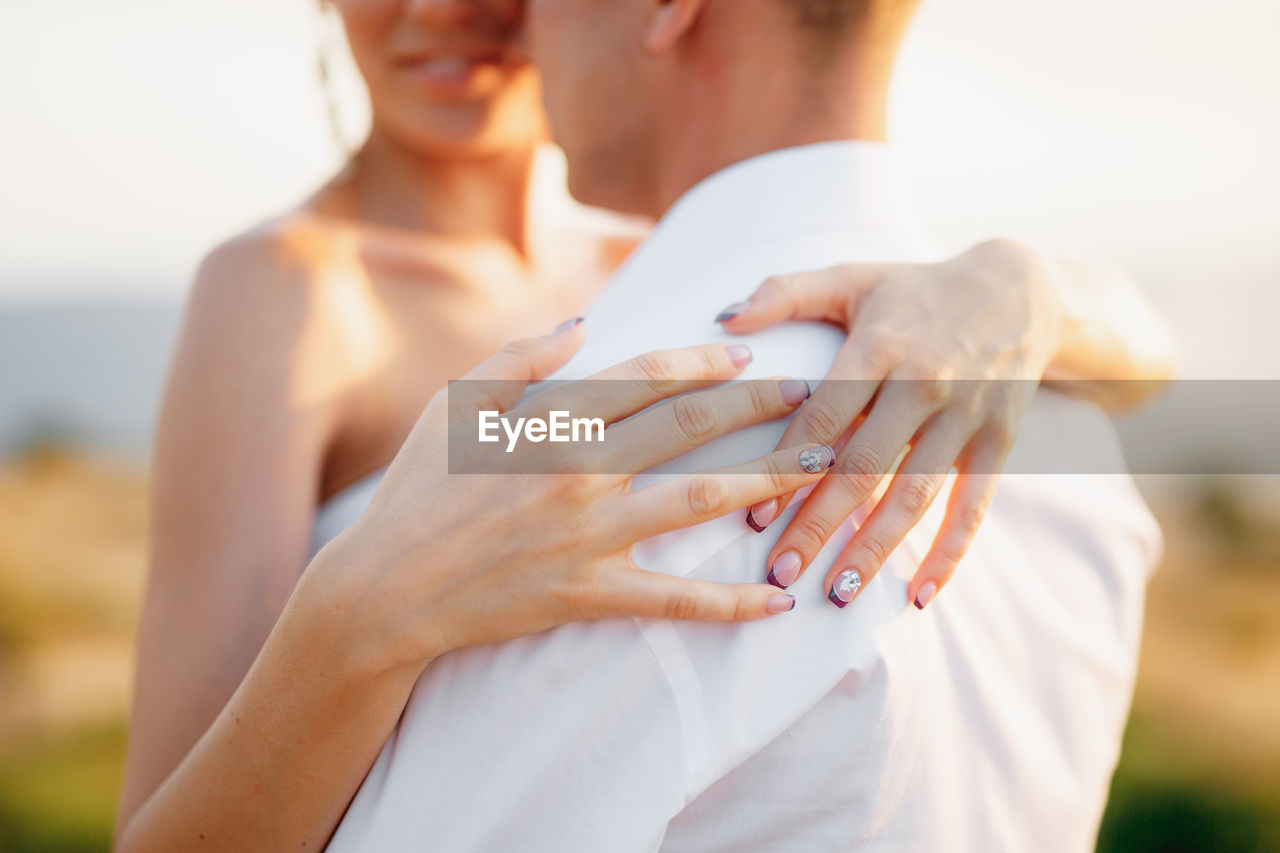 Midsection of couple holding hands