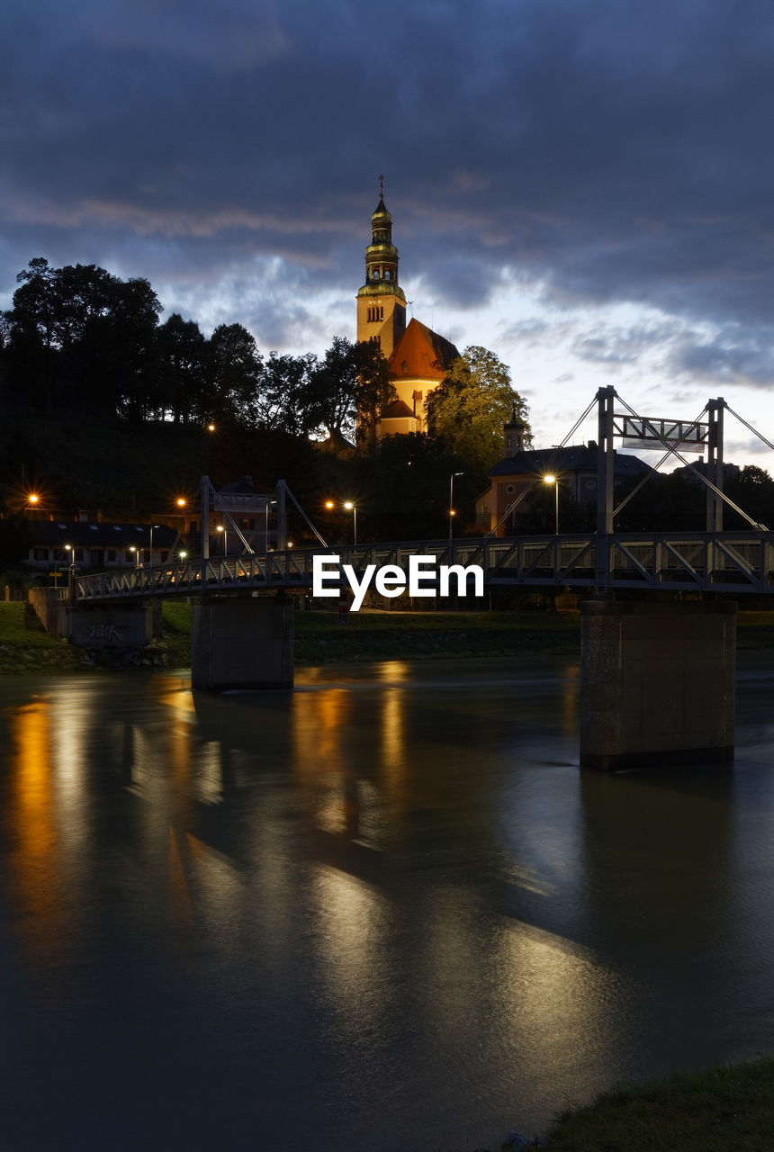 Illuminated bridge over river against sky