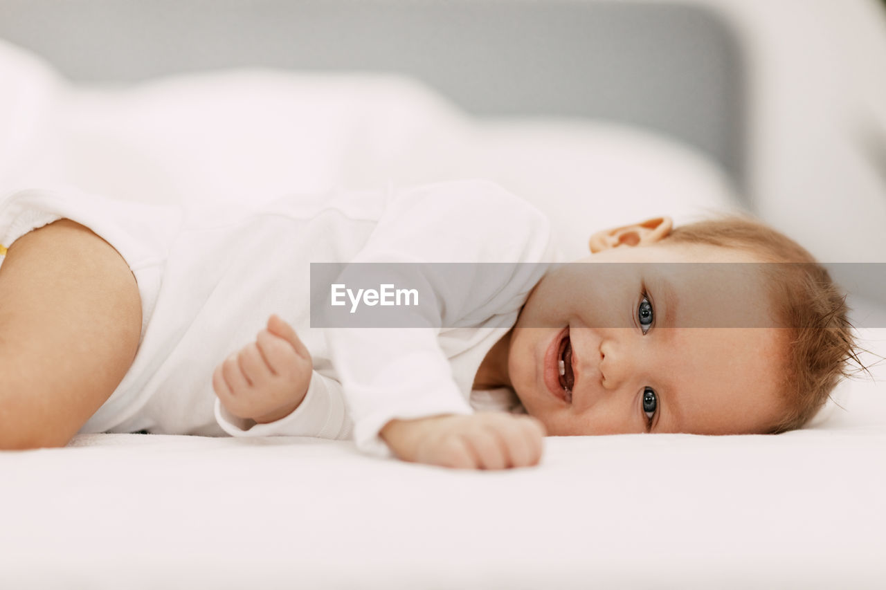 Portrait of cute boy lying on bed