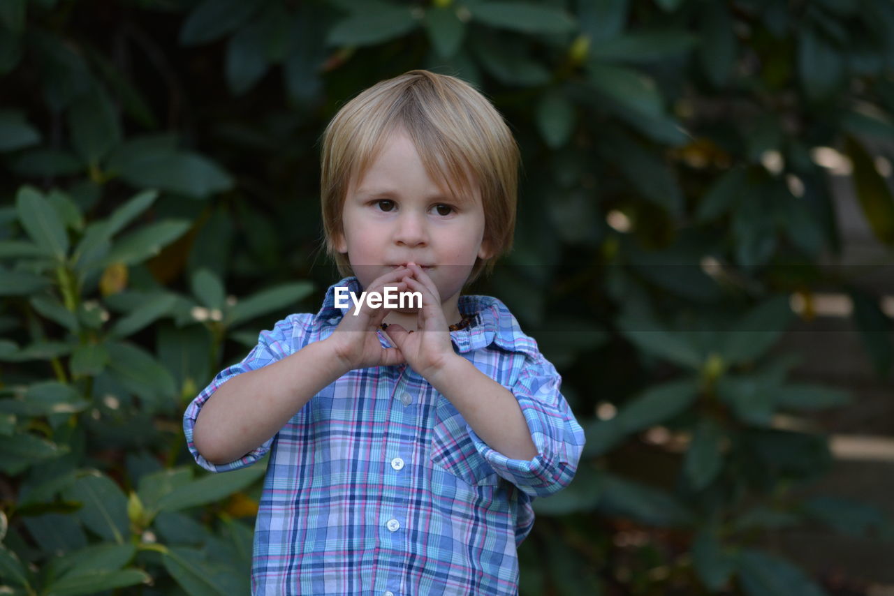 PORTRAIT OF CUTE BOY HOLDING LEAF OUTDOORS