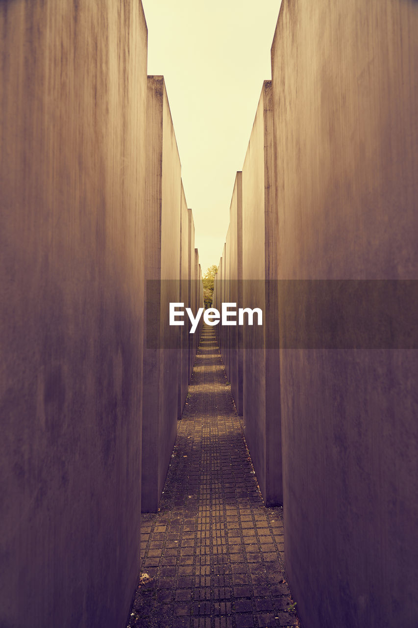architecture, darkness, sunlight, light, morning, the way forward, built structure, diminishing perspective, alley, reflection, no people, white, temple, building, wall, sky, vanishing point, infrastructure, nature, wall - building feature, footpath, shadow, building exterior, city, outdoors, history, yellow, the past, road, black, in a row