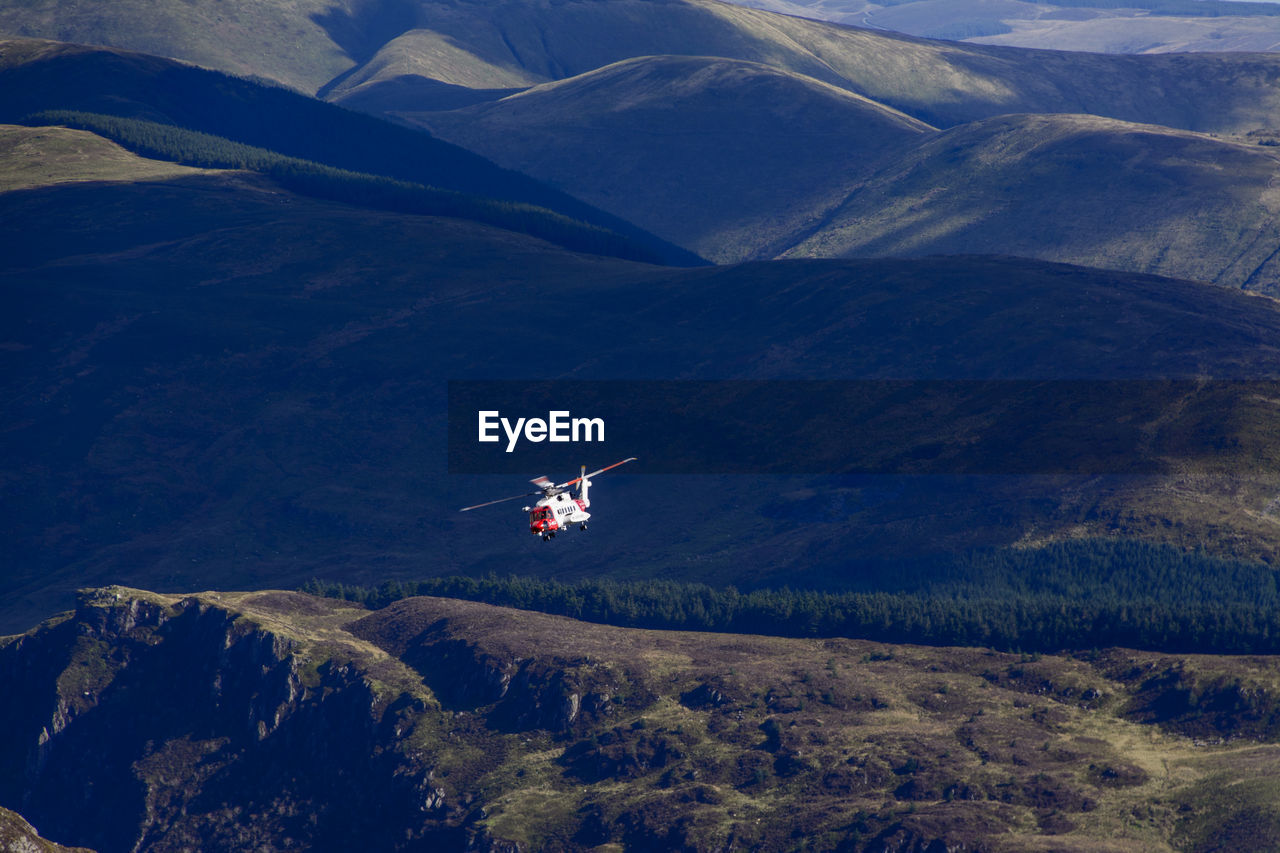 AIRPLANE FLYING OVER MOUNTAINS