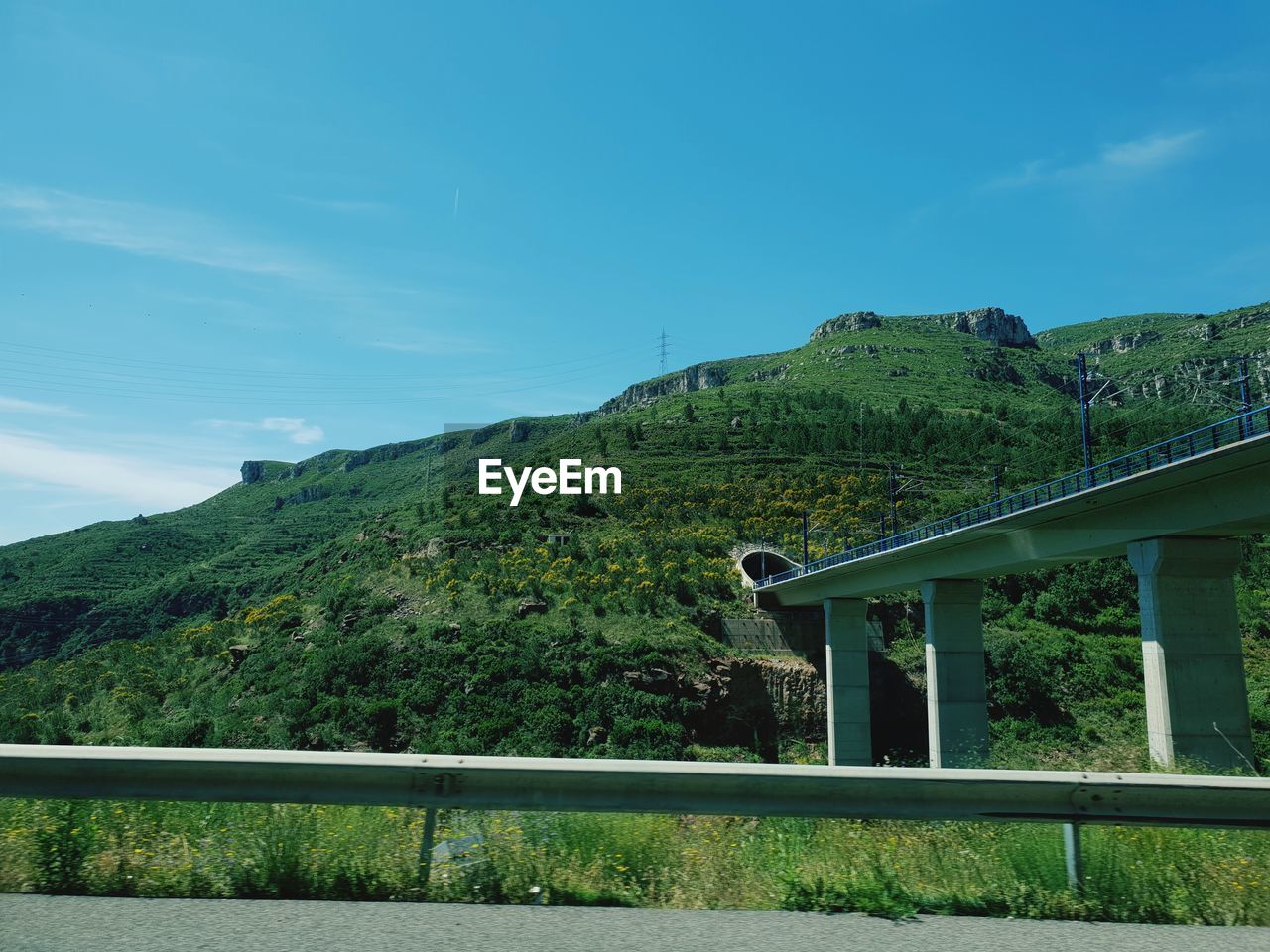 Bridge by mountain against sky