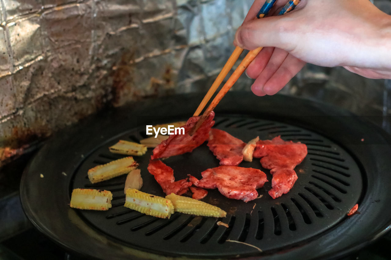 CLOSE-UP OF HAND HOLDING MEAT