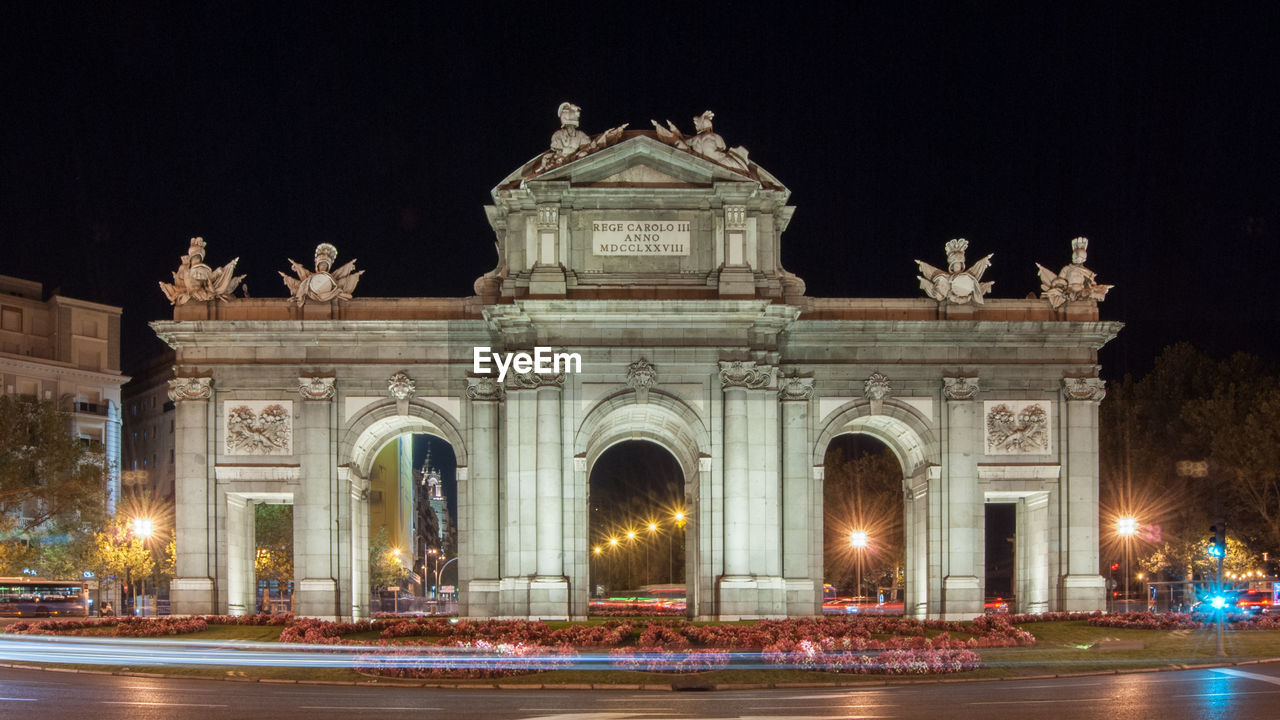 STATUE IN ILLUMINATED CITY