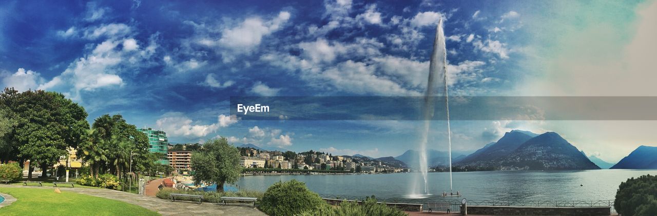 Panoramic view of trees and mountains against blue sky