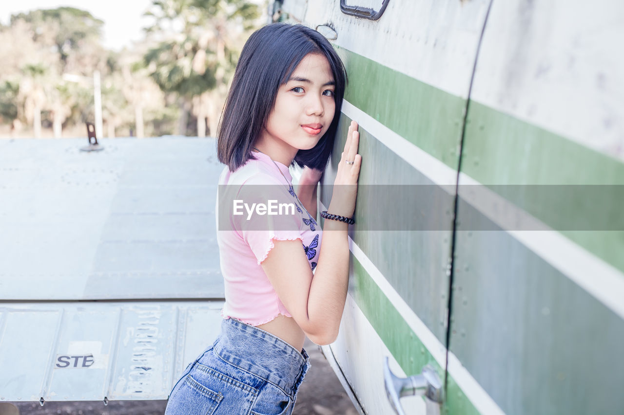 Portrait of beautiful woman standing against wall