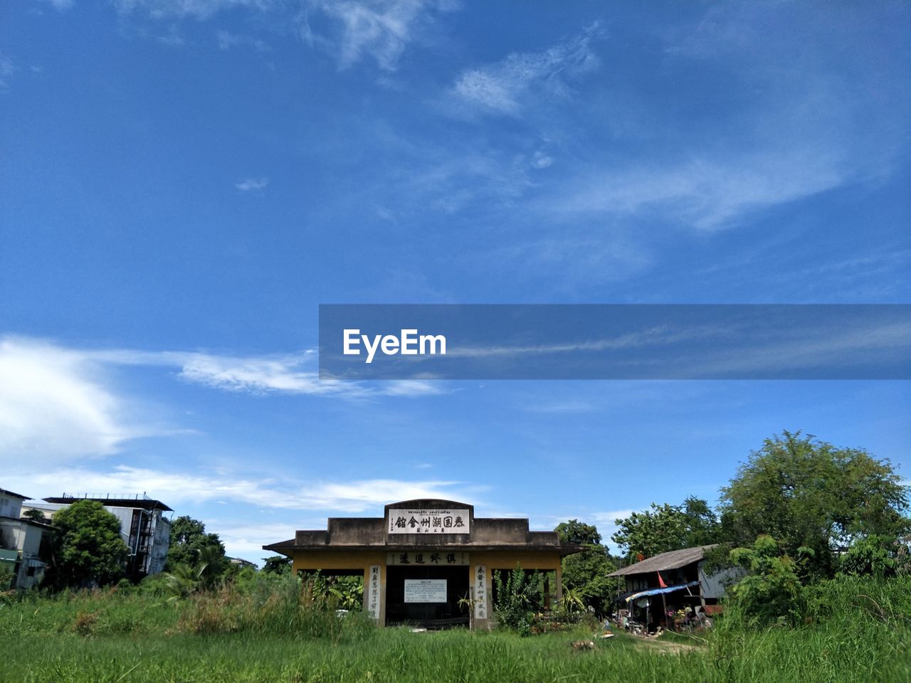 HOUSES AND TREES ON FIELD AGAINST SKY