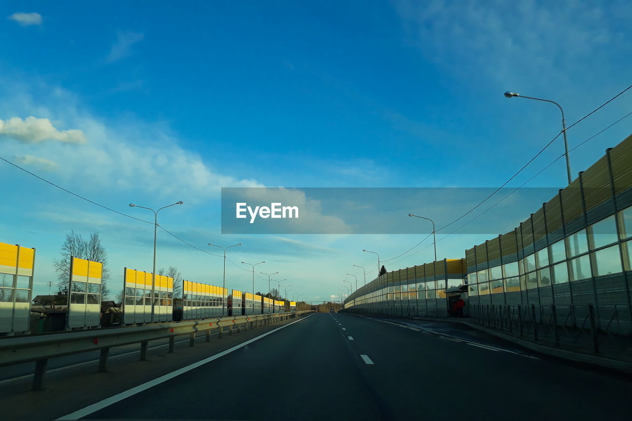 VEHICLES ON ROAD AGAINST SKY