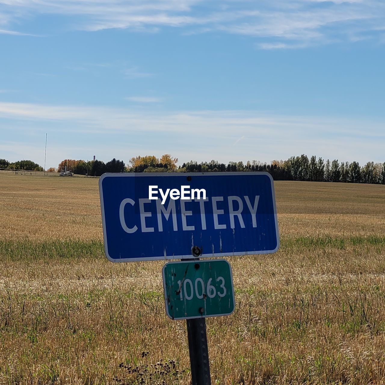 WARNING SIGN ON FIELD AGAINST SKY