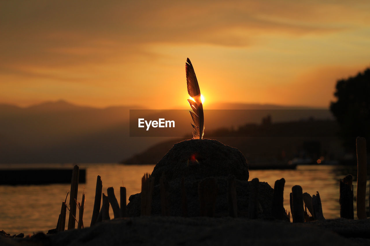 Sand castle at shore of lake chelan against sky during sunset