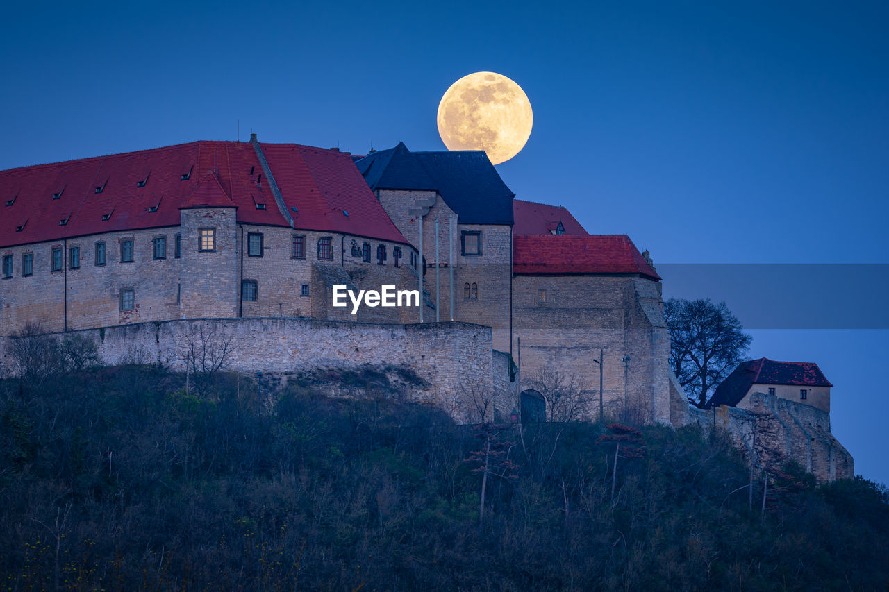 LOW ANGLE VIEW OF HISTORIC BUILDING AGAINST SKY AT DUSK