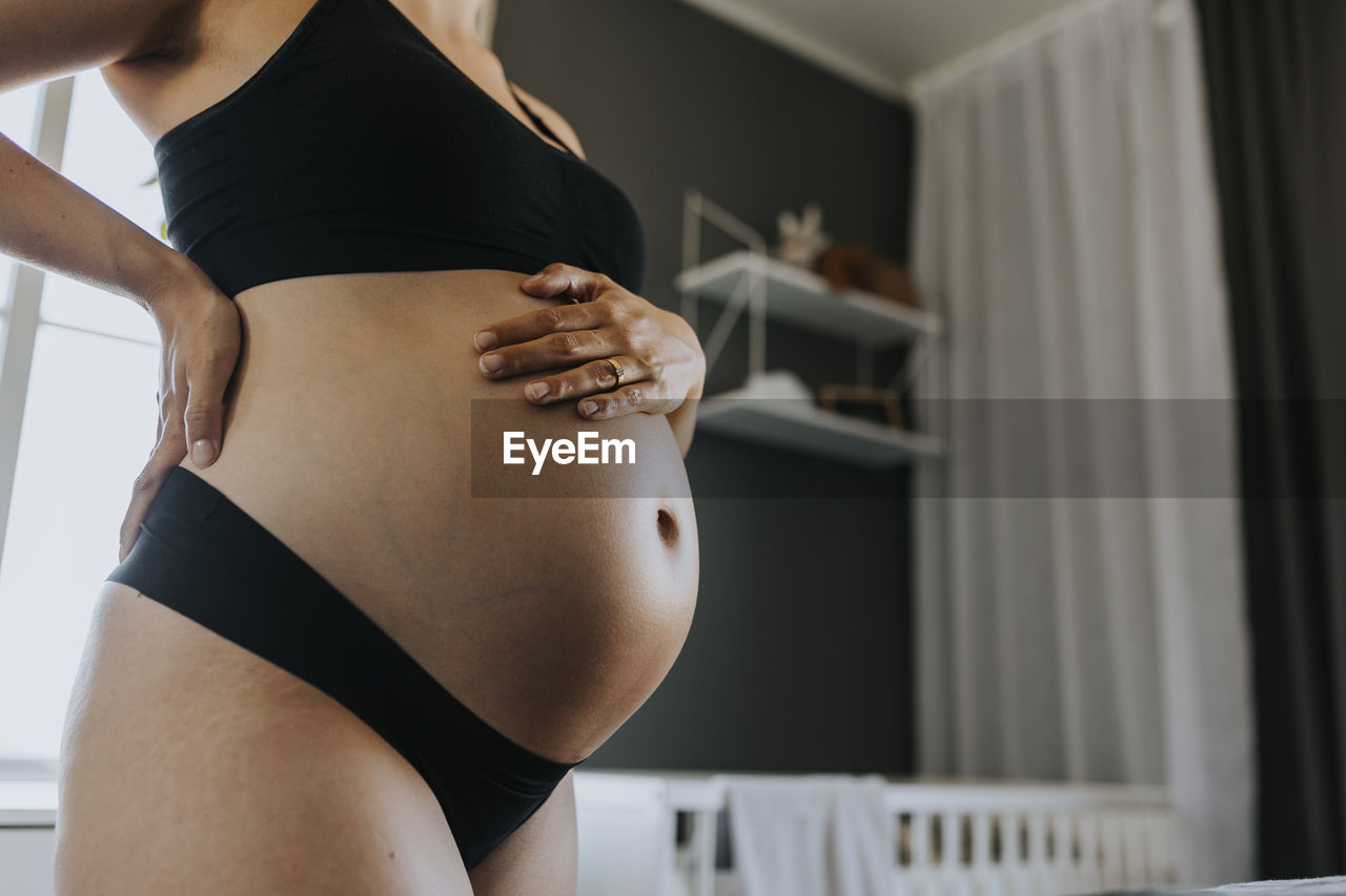 Close-up of pregnant woman touching belly