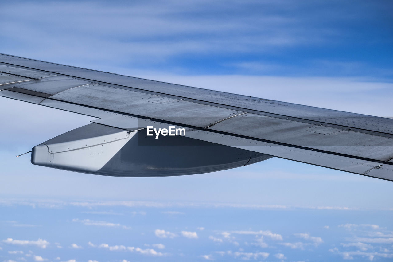 LOW ANGLE VIEW OF AIRPLANE WING AGAINST SKY