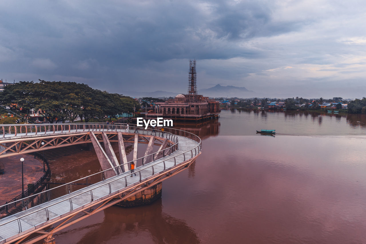 View of bridge over water against cloudy sky